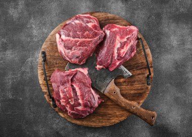 Koyu gri bir yüzeyde çiğ domuz yanakları ve baharatlar. Üst görünüm. 