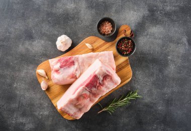 İki parça çiğ domuz yağı ve ahşap tahtada baharatlar, üst manzara..