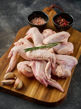 Ahşap tahtada biber ve tuz ile pişirilmemiş tavuk kanatları. Çiğ et. Çiğ tavuk kanatları