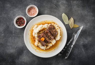 Beyaz tabakta patates püresi ve sığır eti yanakları.