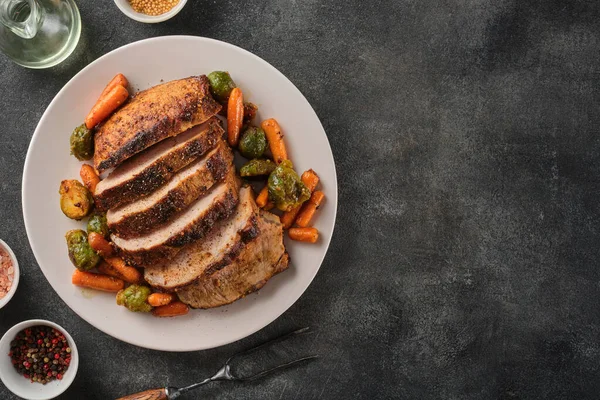 Roasted pork Loin with carrot and broccoli. Grilled sliced Pork Meat. Top view. Copy space.