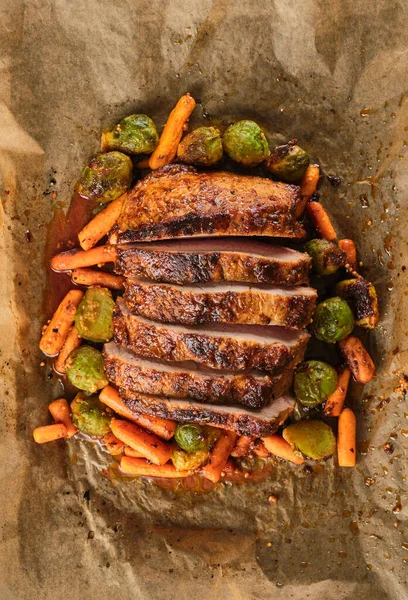 Roasted pork Loin with carrot and broccoli. Grilled sliced Pork Meat.