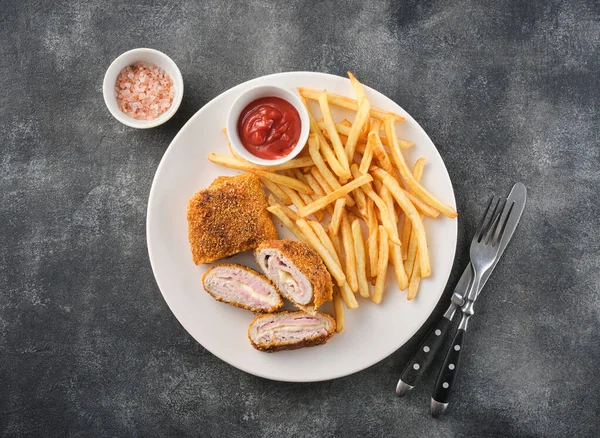 Cordon bleu and french fries. Chicken cordon bleu schnitzel, meat wrapped around ham and cheese, breaded and fried.