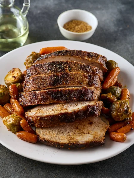 Roasted pork Loin with carrot and broccoli. Grilled sliced Pork Meat.