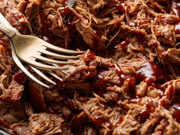 Traditional barbecue pulled pork. Slow cooked pulled pork shoulder. Juicy pork meat cooked in a smoker by low and slow.