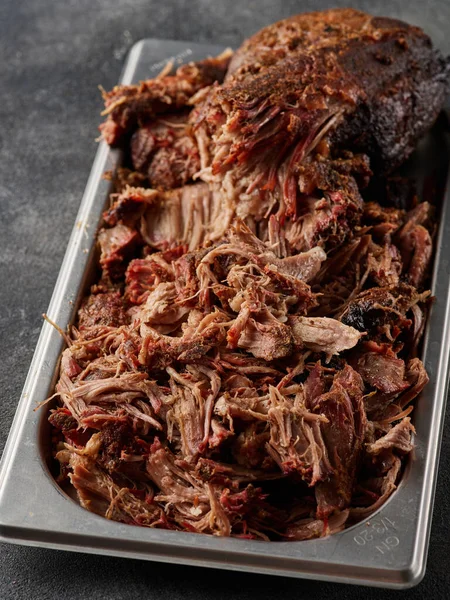 Traditional barbecue pulled pork. Slow cooked pulled pork shoulder. Juicy pork meat cooked in a smoker by low and slow.