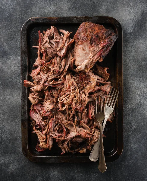 Traditional barbecue pulled pork. Slow cooked pulled pork shoulder. Juicy pork meat cooked in a smoker by low and slow.