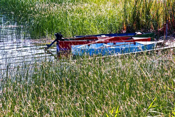 Barcos pequeños atracados en la orilla de un lago Imagen De Stock