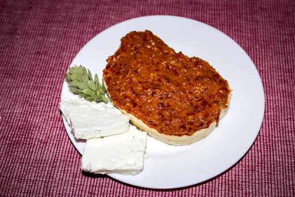 Ajvar - gerösteter roter Pfeffer und Auberginenaufstrich auf Brot mit weißem Käse lizenzfreie Stockbilder