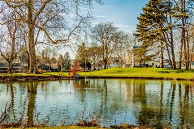 Pond with reflection in the water and the Tea dome or Gloriette on a hill in the background in the park Proosdij, wonderful sunny winter day in Meerssen, South Limburg in the Netherlands