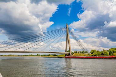 Beautiful view of the cable-stayed Lanaye bridge, which crosses the Albert Canal with green vegetation in the background, wonderful sunny summer day in Belgium