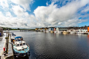 River Shannon with boats anchored on the coast and picturesque houses in the town of Athlone, wonderful and relaxed day in the county of Westmeath, Ireland