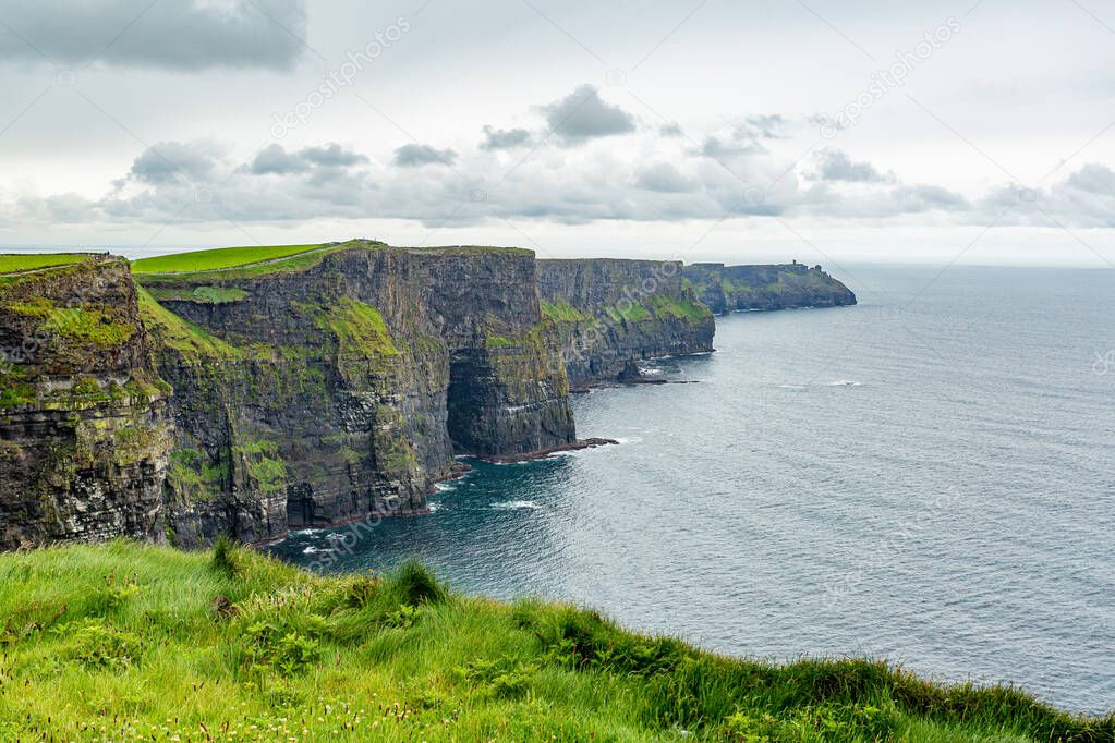 The famous and tourist Cliffs of Moher, geosites and geopark, Wild Atlantic Way, wonderful spring cloudy day in the countryside in county Clare in Ireland