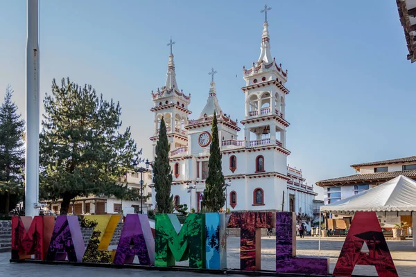Church of San Cristbal in eclectic style with its white walls and small detanes in red with the word Mazamitla in front on a beautiful day in Jalisco, Mexico