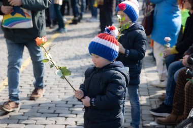 Roermond, Limburg, Hollanda. 6 Mart 2022. Rusya 'nın Ukrayna' ya silahlı saldırısını protesto etmek. Bir grup insan barışçıl bir gösteri yapıyor. Barışseverlik kavramı. Elinde gül olan bir çocuk.