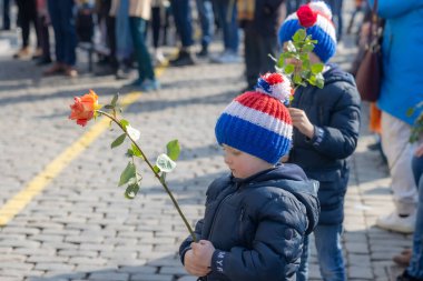 Roermond, Limburg, Hollanda. 6 Mart 2022. Rusya 'nın Ukrayna' yı işgal etmesini protesto etmek için elinde gül olan bir çocuk. Bir grup insan barışçıl bir gösteri yapıyor. Barışseverlik kavramı