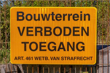 Sarı metal plakada Bouwterrein Verboden Toegang yazıyor. Sanat 461 Wetb. Hollandaca van strafrecht, yani inşaat alanı, izinsiz giriş yasak. Sanat 461 yasası. ceza hukuku