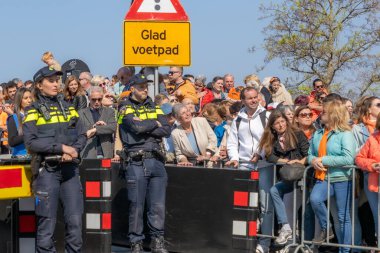 Maastricht, Güney Limburg, Hollanda. 27 Nisan 2022. Kralın kutlamalarında polis gücü, şehirde eğlenen insanlar, güneşli bir bahar günü. Portakal festivali geleneği