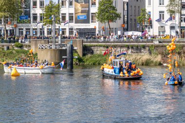 Maastricht, Güney Limburg, Hollanda. 27 Nisan 2022. Hollanda 'da Krallar Günü kutlaması, tekneler ve mutlu insanlar kutlama ve eğlenme, güneşli bahar günü. Portakal festivali geleneği
