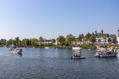 Maastricht, South Limburg, Netherlands. April 27, 2022. King's day celebration in Holland, boats and happy people celebrating and enjoying, sunny spring day. Tradition of an orange festival