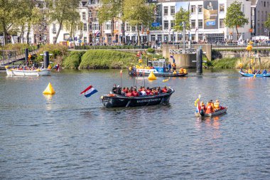 Maastricht, South Limburg, Netherlands. April 27, 2022. King's day celebration in Holland, boats and happy people celebrating and enjoying, sunny spring day. Tradition of an orange festival