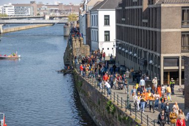 Maastricht, Güney Limburg, Hollanda. 27 Nisan 2022. Hollanda 'da Krallar Günü kutlaması. Mutlu insanlar şehirde kutlama yapıyor ve eğleniyor. Güneşli bahar günü. Portakal festivali geleneği