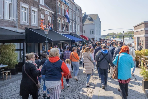 Maastricht, Güney Limburg, Hollanda. 27 Nisan 2022. Hollanda 'da Krallar Günü kutlaması. Mutlu insanlar şehirde kutlama yapıyor ve eğleniyor. Güneşli bahar günü. Portakal festivali geleneği