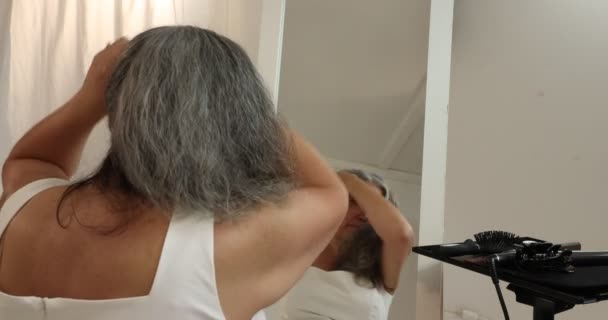 Ώριμη Γυναίκα Αρχίζει Δένει Χαλαρά Γκρίζα Μαύρα Κυματιστά Μαλλιά Της — Αρχείο Βίντεο