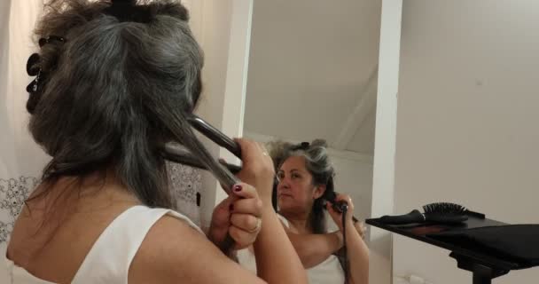 Dojrzała Kobieta Oddzielająca Kosmyk Szaro Czarnych Falowanych Włosów Aby Wyprostować — Wideo stockowe