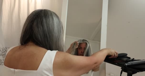 Mature Woman Concentrating Process Straightening Wavy Gray Black Hair Herself — Stockvideo