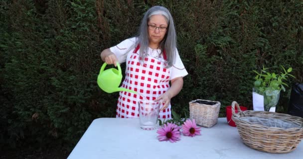 Mature Woman Working Putting Water Glass Vase Removing Green Leaves — Stockvideo