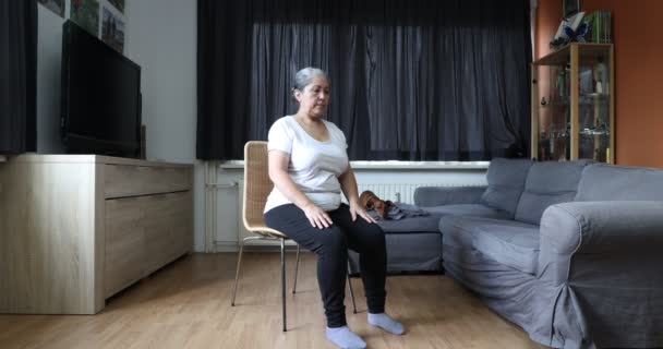 Ανώτερη Γυναίκα Κάνει Ασκήσεις Κάθεται Μια Καρέκλα Τεντώνει Χέρια Και — Αρχείο Βίντεο