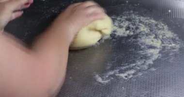 Metal bir yüzeyde hamur yoğurarak badem unu, mozarella peyniri, yumurta, krem peynir ve kabartma tozu kullanan düşük karbonhidratlı simit yapan kadın elleri. Sağlıklı ev yapımı gıda konsepti