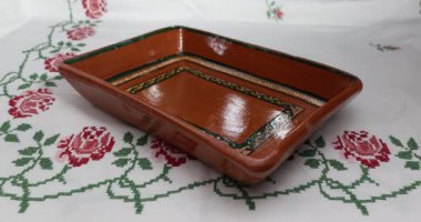 Meksika kil tepsisine iki taze chayote yerleştiren kadın eller, çapraz dikişli çiçekler, labu siam, organik sebzeler. Biyolojik, biyolojik ve evde yetiştirme kavramı