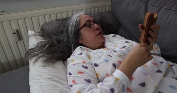 Mulher Adulta Sênior Deitada Relaxada Travesseiros Sofá Com Seu Telefone — Vídeo de Stock