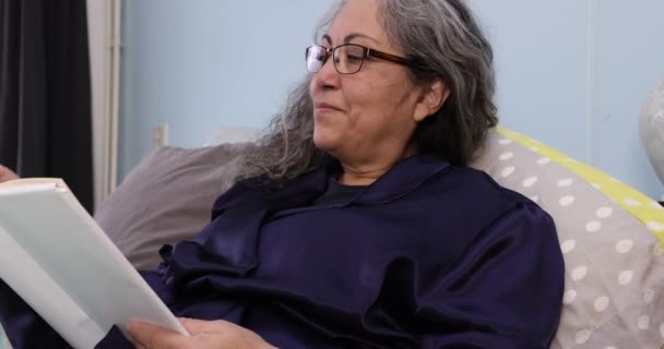 Idősebb Felnőtt Kényelmesen Fekszik Ágyán Olvasva Egy Könyvet Nyugodt Kifejezés — Stock videók