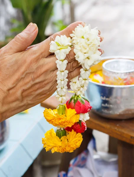 Les mains de la femme tiennent la fleur vive pour le festival thaïlandais Songkran — Photo