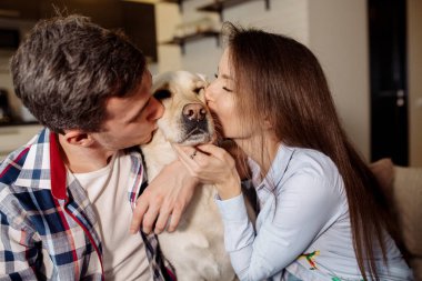 Genç çift ve tüylü bebek labrador av köpekleri mutfakta.