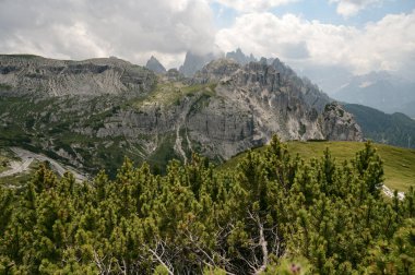 İtalya, Tre Cime 'deki Dolomite Dağları, güneşli yaz gününde mavi gökyüzü boyunca yeşil çimen önü