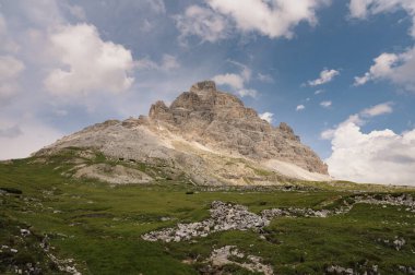 İtalya, Tre Cime 'deki Dolomite Dağları, güneşli yaz gününde mavi gökyüzü boyunca yeşil çimen önü