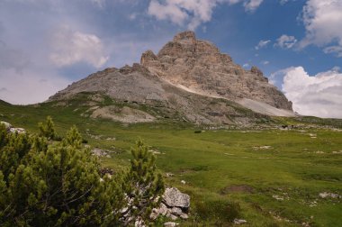 İtalya, Tre Cime 'deki Dolomite Dağları, güneşli yaz gününde mavi gökyüzü boyunca yeşil çimen önü