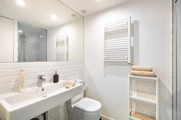 Belső tér fehér fürdőszoba felújított lakásban. Zuhanyzóna fűtőberendezéssel, mosogatóval és tükörrel — Stock Fotó