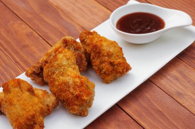 Barbekü soslu kızarmış tavuk kanadı. Ahşap masada kızarmış tavuk var. Kızarmış yemek..