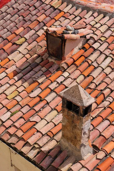 Vieille fenêtre grenier et cheminée en brique sur le toit d'une maison de village par une journée ensoleillée. Toiture de style vintage. — Photo