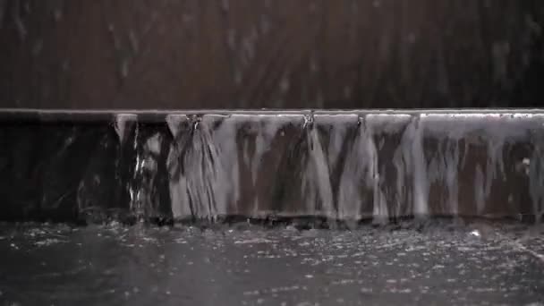 Langzame beweging van het water dat de trap afloopt. Ongecontroleerd water op straat. Close-up van de waterval op een fontein. — Stockvideo