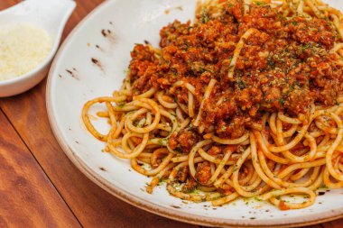 Spagetti bolonez, kıyma ve sebzeli makarna. Ahşap arkaplanda yatay yan görünüm