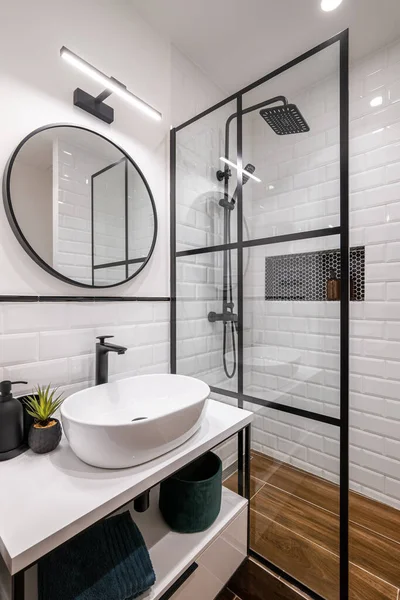Egyszerű fürdőszoba fekete zuhanyzóval, kerek tükör és klasszikus fehér csempe — Stock Fotó