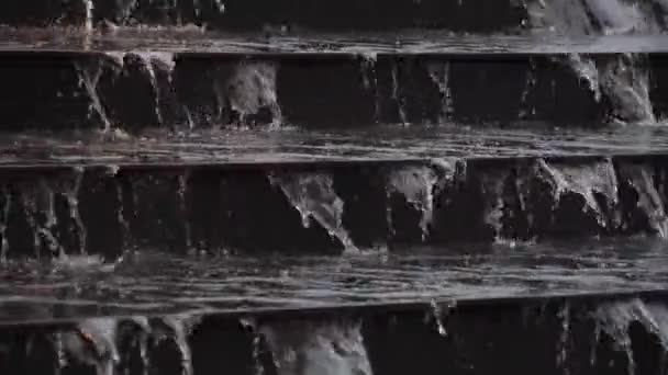 La cámara lenta de agua fluye por las escaleras. Primer plano de la cascada en una fuente. — Vídeo de stock