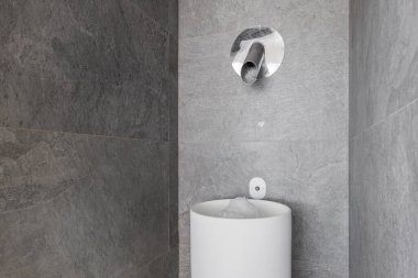 Sağlık merkezinde gri mermer duvarları olan modern bir saunada buz üreticisi..