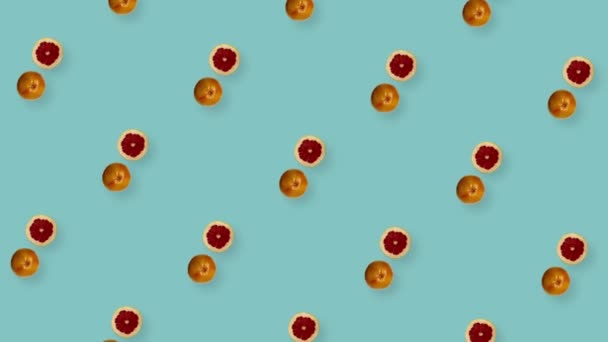 Modèle de fruits colorés de pamplemousses frais tournants sur fond bleu. Modèle sans couture avec des tranches de pamplemousse. Animation réaliste. Mouvement vidéo 4K — Video